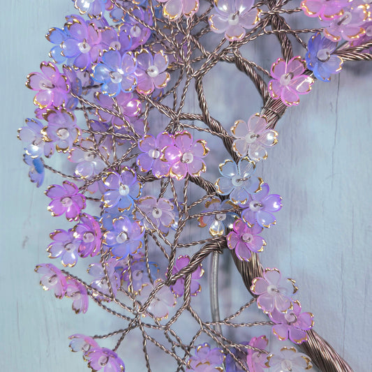 Decorative floral branch with purple and pink flowers on a light blue background