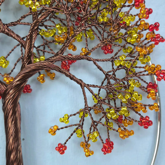 Decorative wall art of a tree with colorful beads on a light blue background