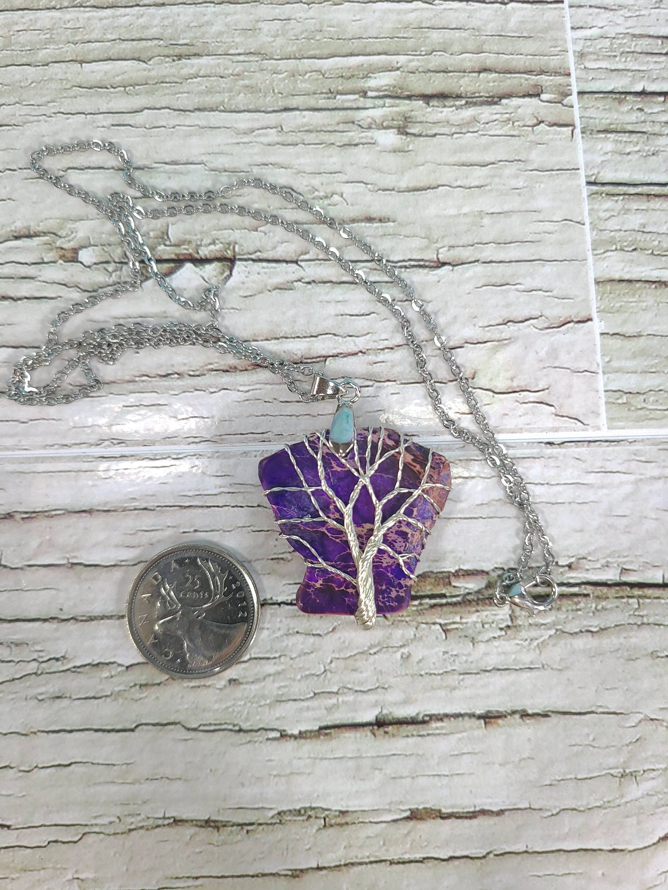 Necklace with a tree of life pendant on a textured surface