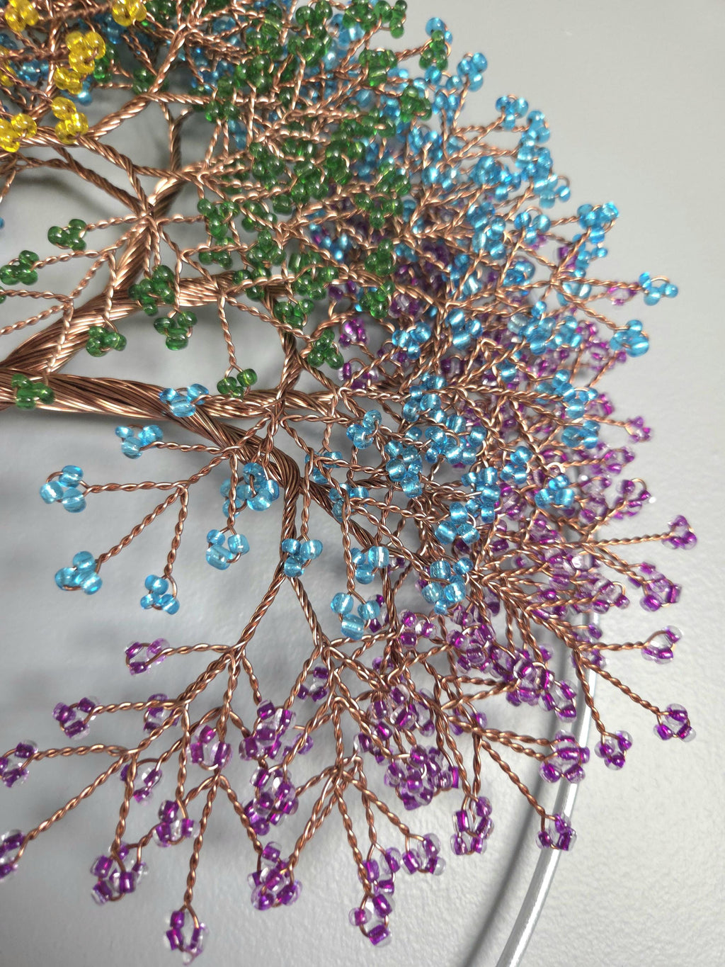 Decorative branch with colorful beads on a neutral background