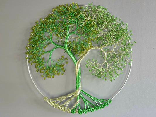 Decorative wall art of a tree with green leaves on a gray background