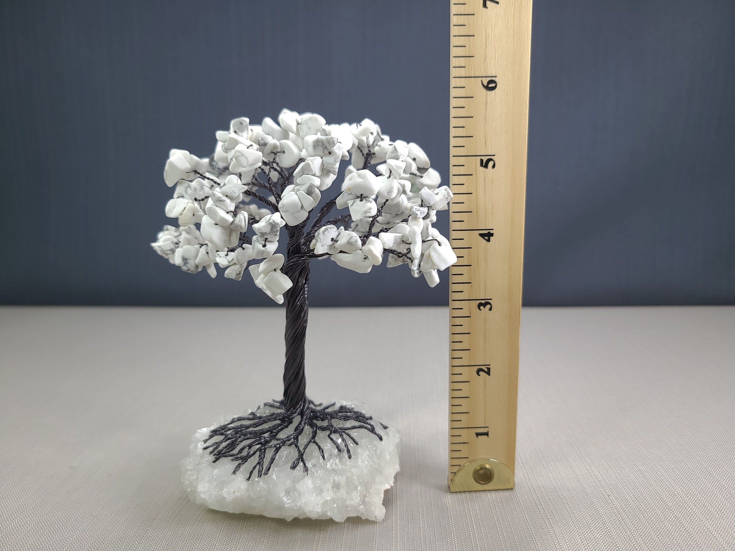 Decorative white tree with a ruler for scale on a gray background