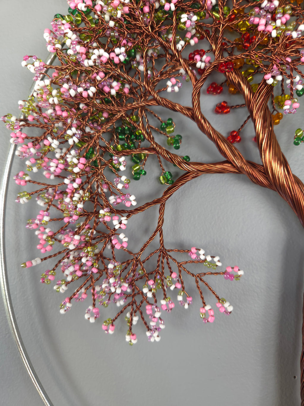 Decorative wall art of a tree with colorful beads on a gray background