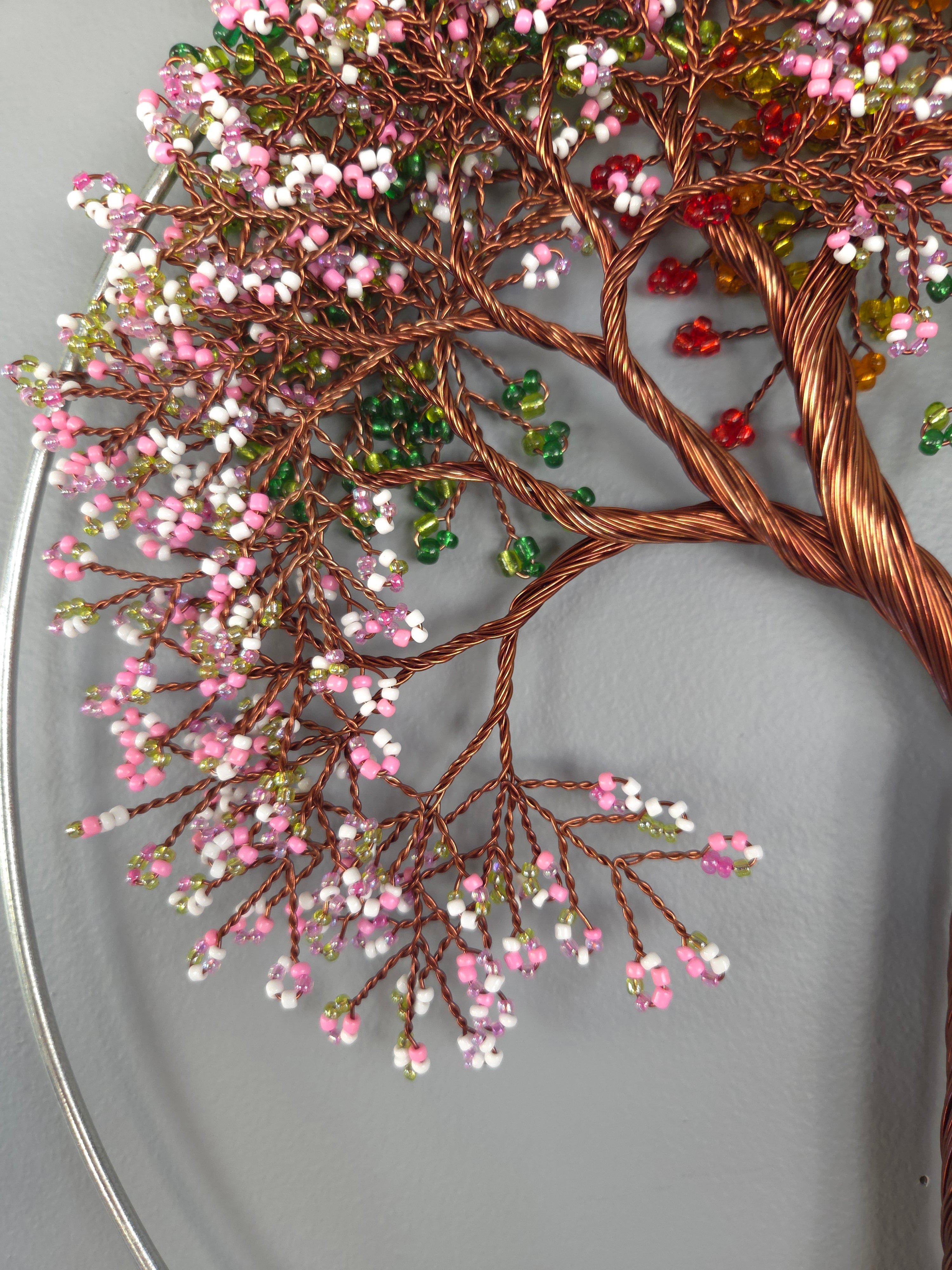Decorative wall art of a tree with colorful beads on a gray background
