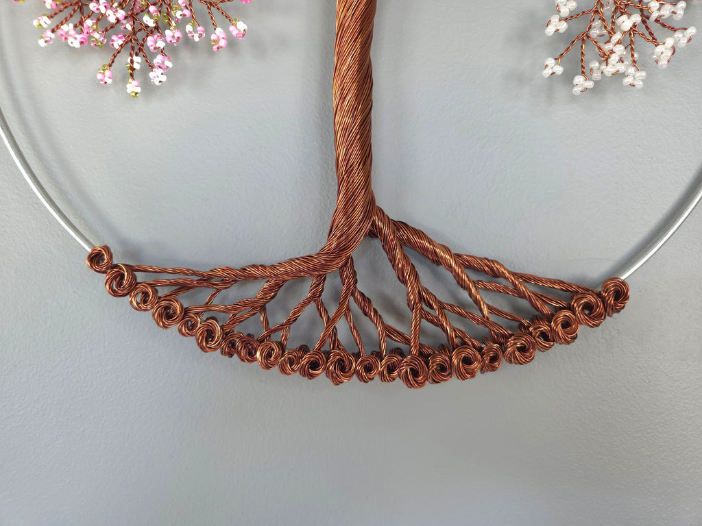 Close-up of a copper wire tree branch necklace on a light gray background