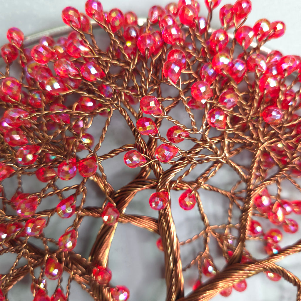 Close-up of red beaded branch-like structure on a white background