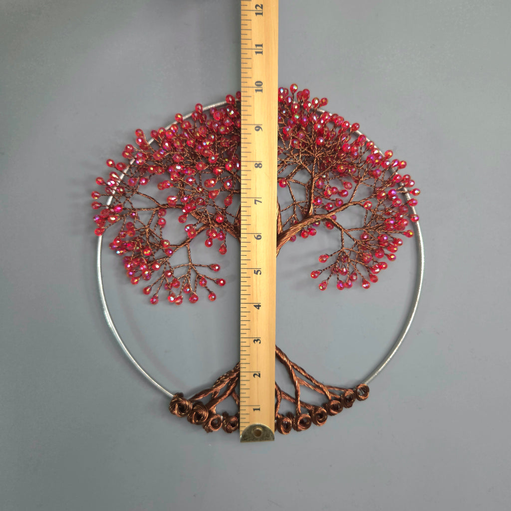 Decorative wall art with a tree design and red berries, measured against a ruler on a gray background.