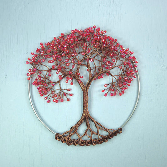 Decorative wall art of a tree with red berries on a light blue background