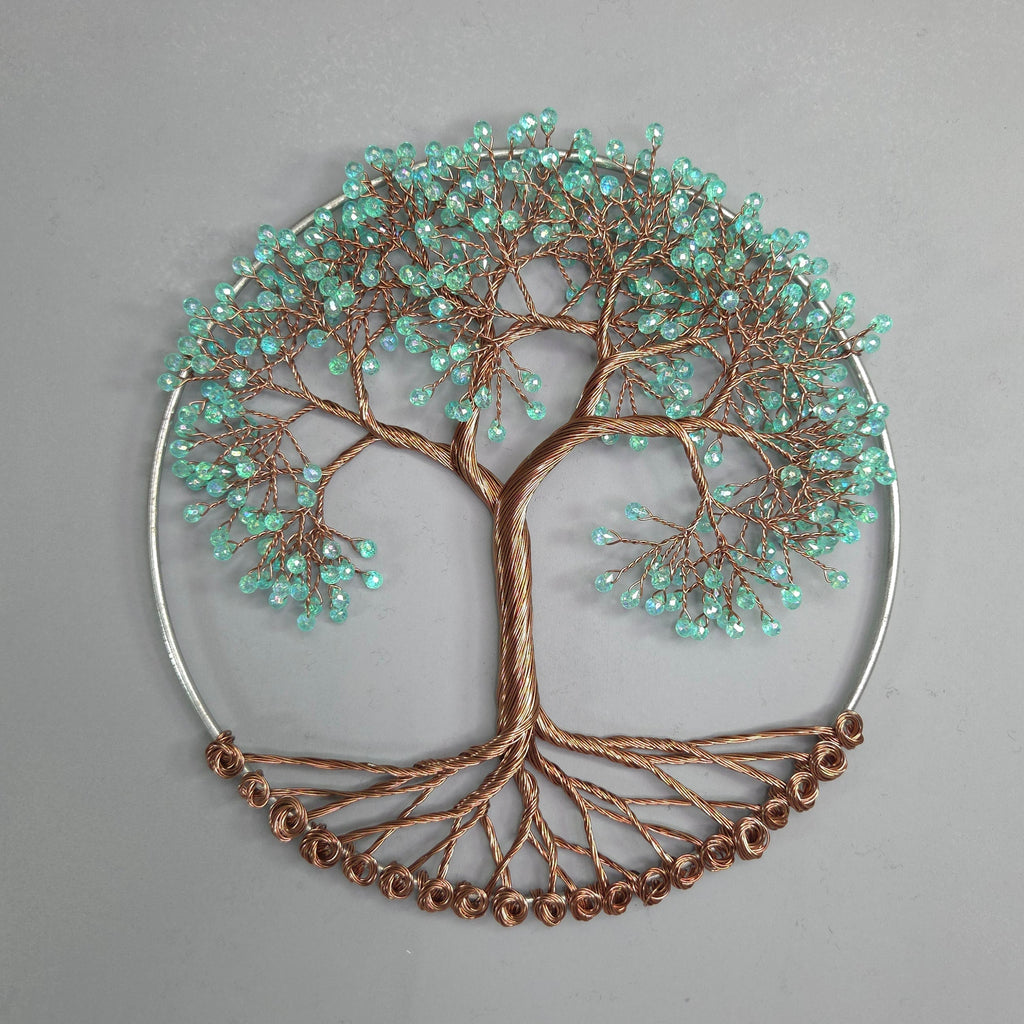 Decorative wall art piece with tree design and turquoise beads on a gray background