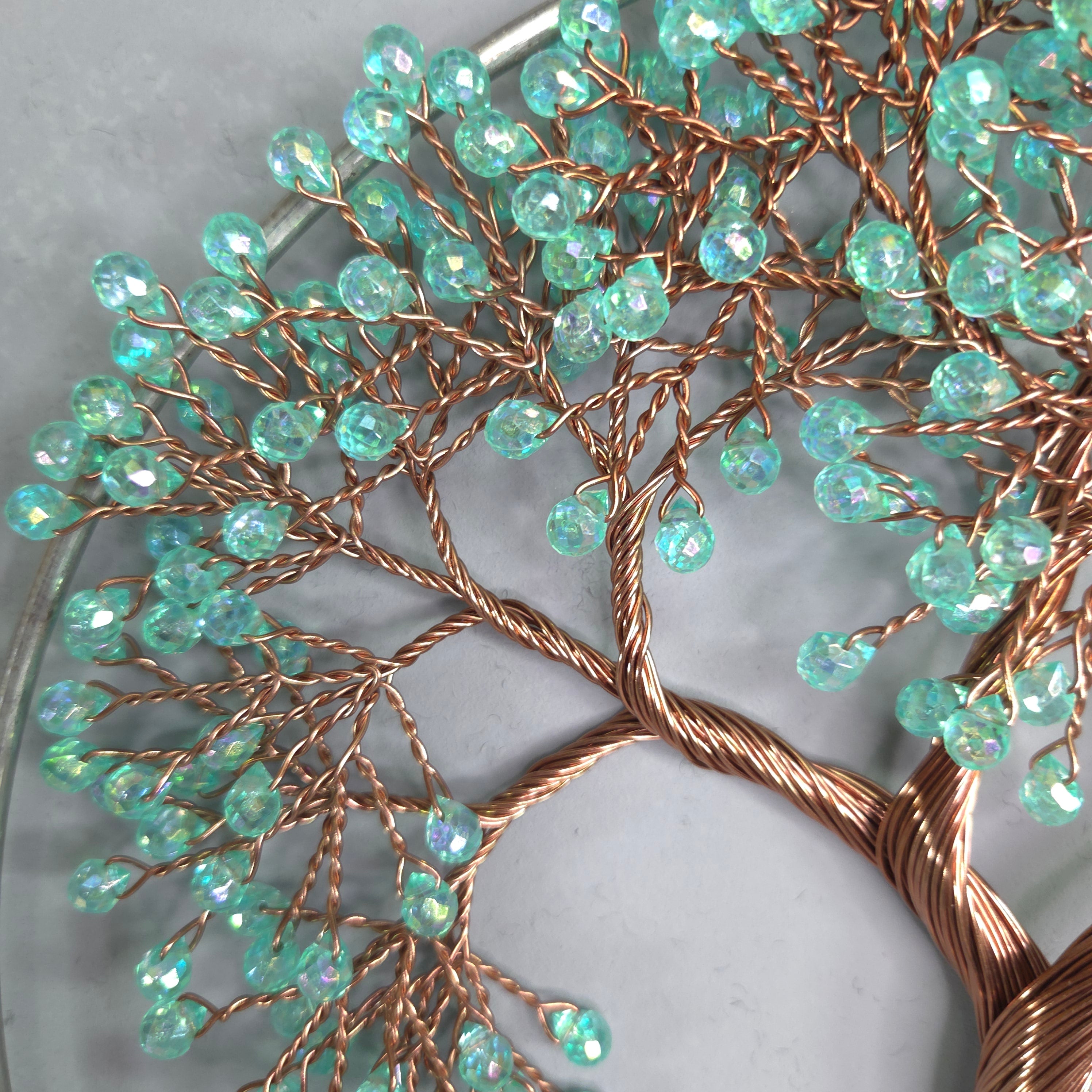 Decorative wreath with turquoise beads and copper wire on a marble surface