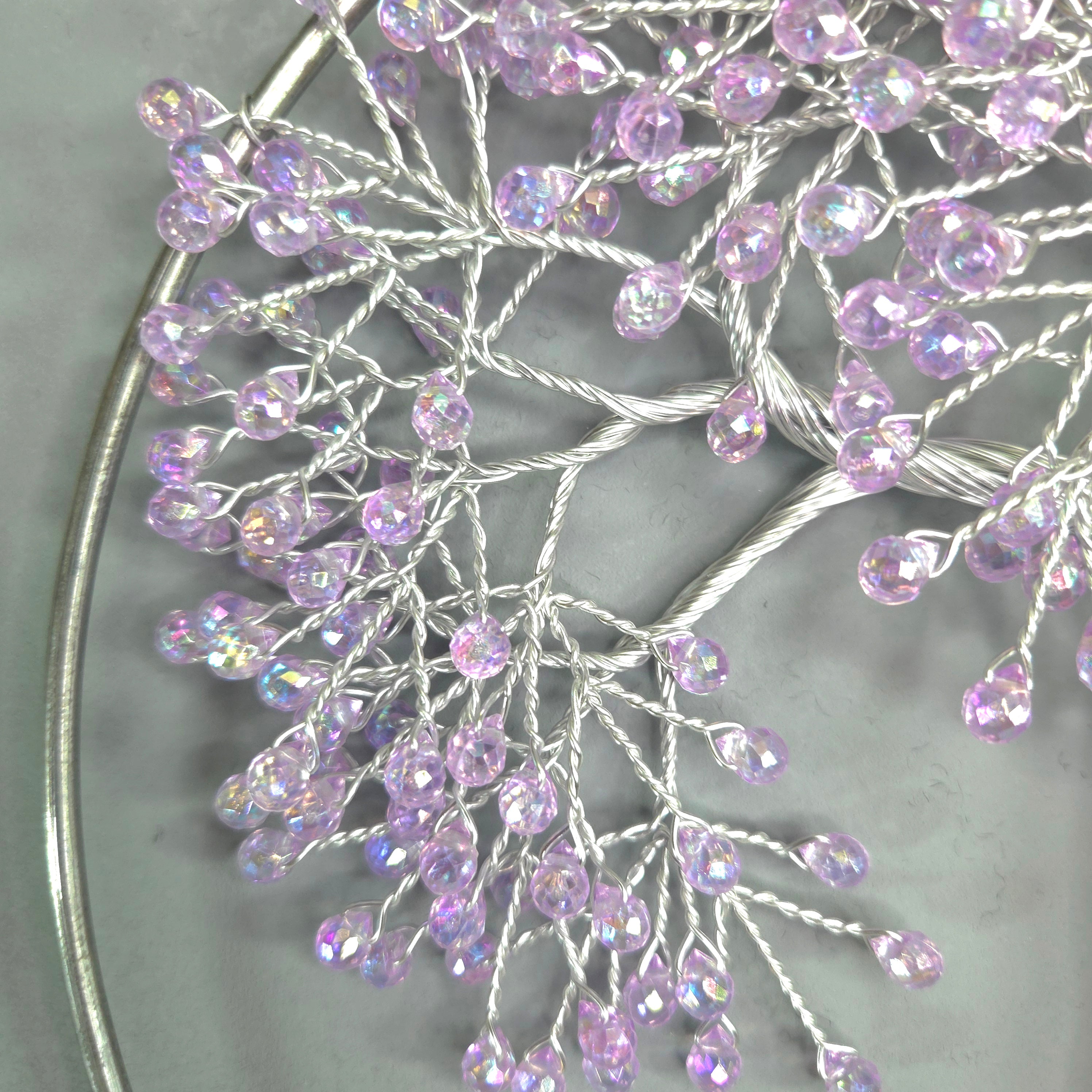 Decorative branch with purple beads on a gray background