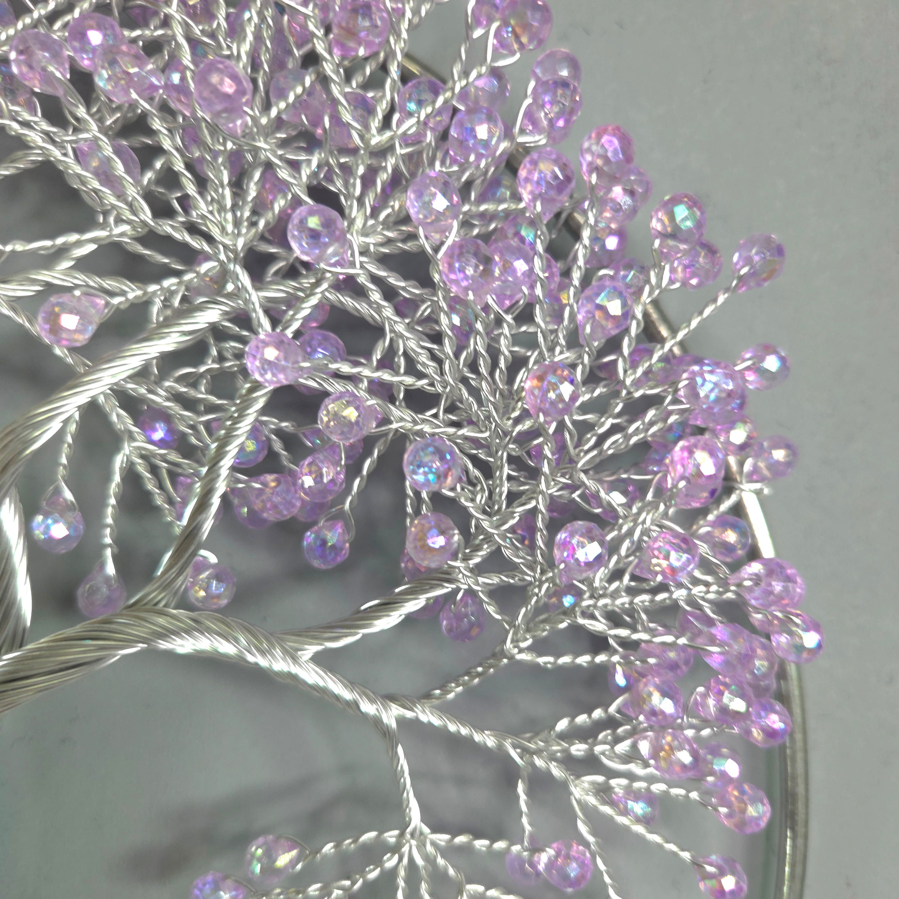 Decorative branch with purple beads on a gray background