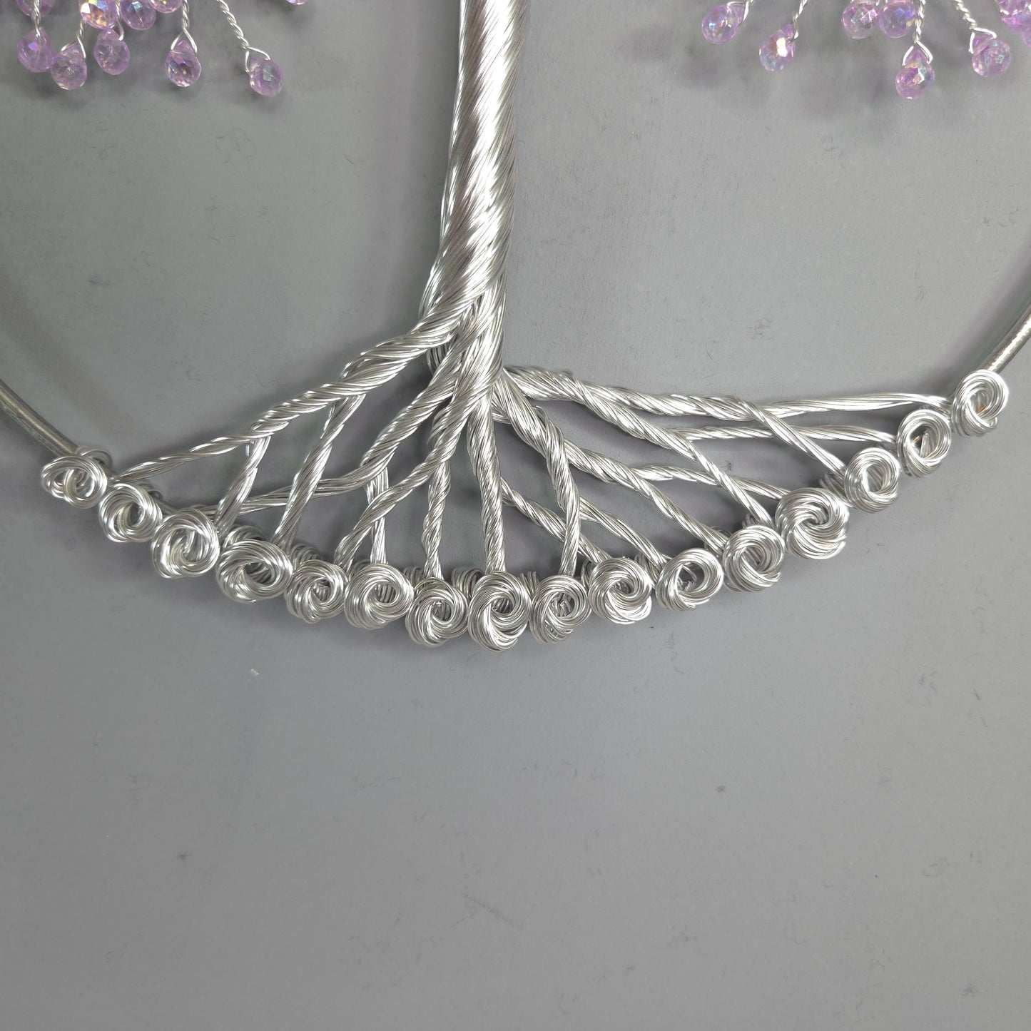 Silver tree-shaped hairpin with small beads on a gray background