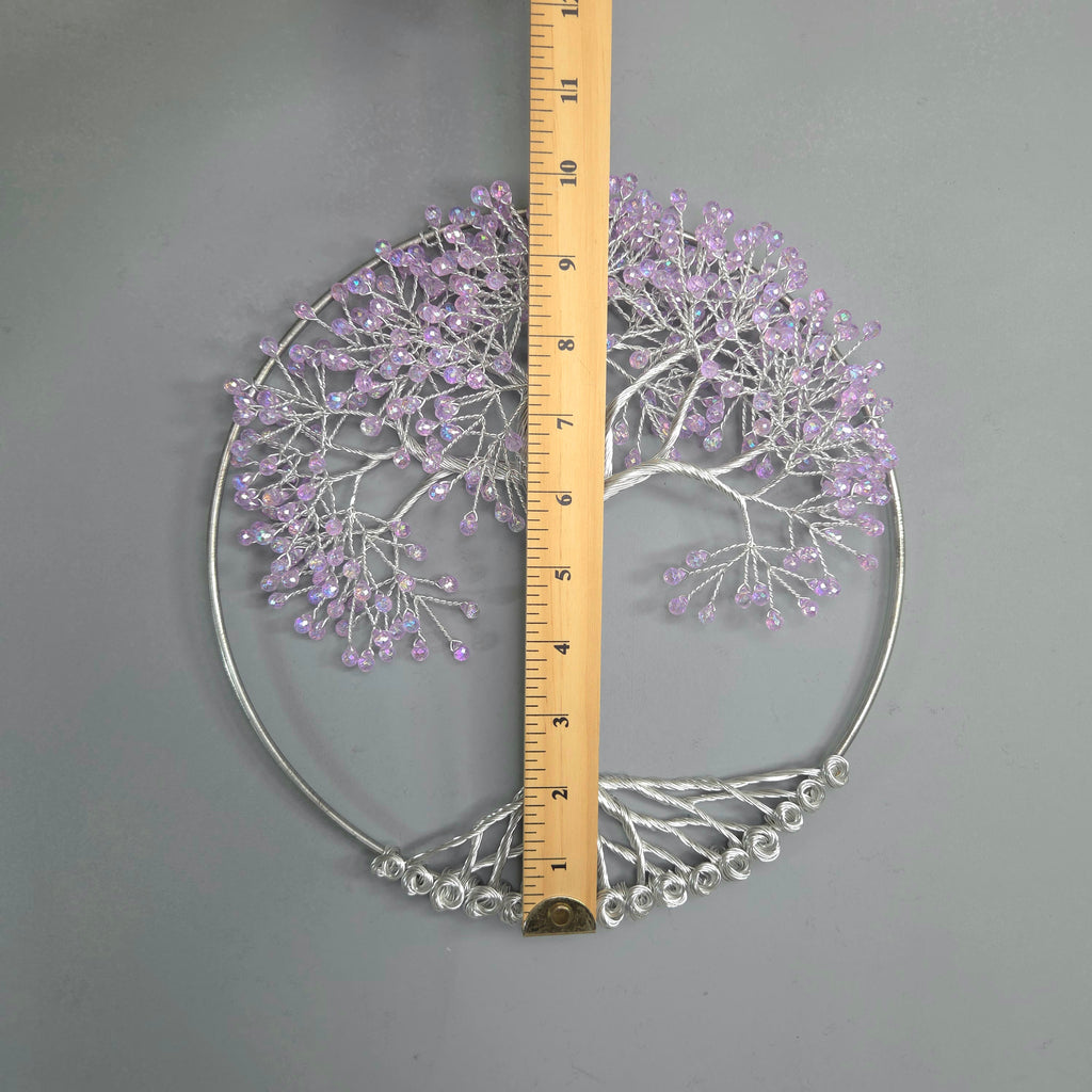 Decorative metal wall art with purple accents and a ruler for scale on a gray background