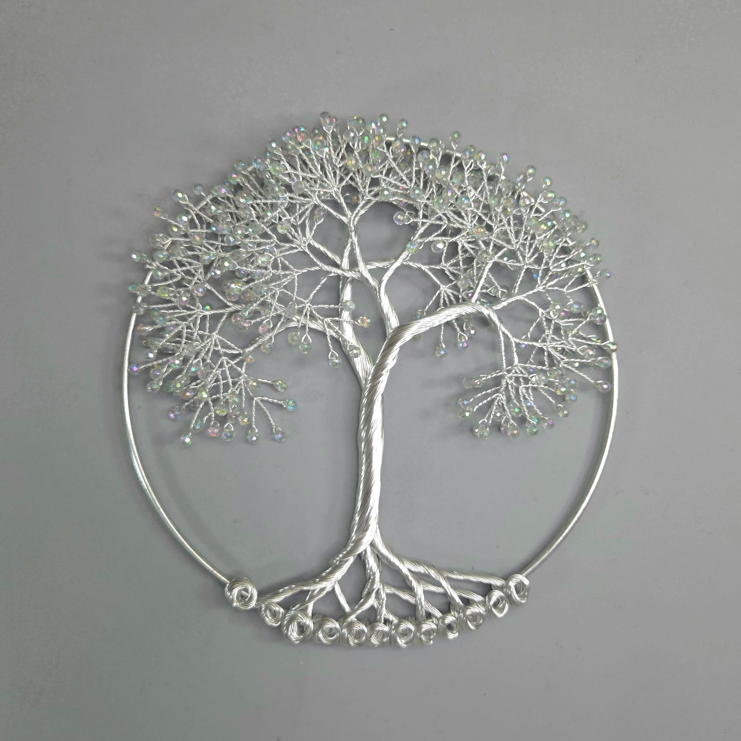 Silver tree-shaped decorative wall art on a gray background