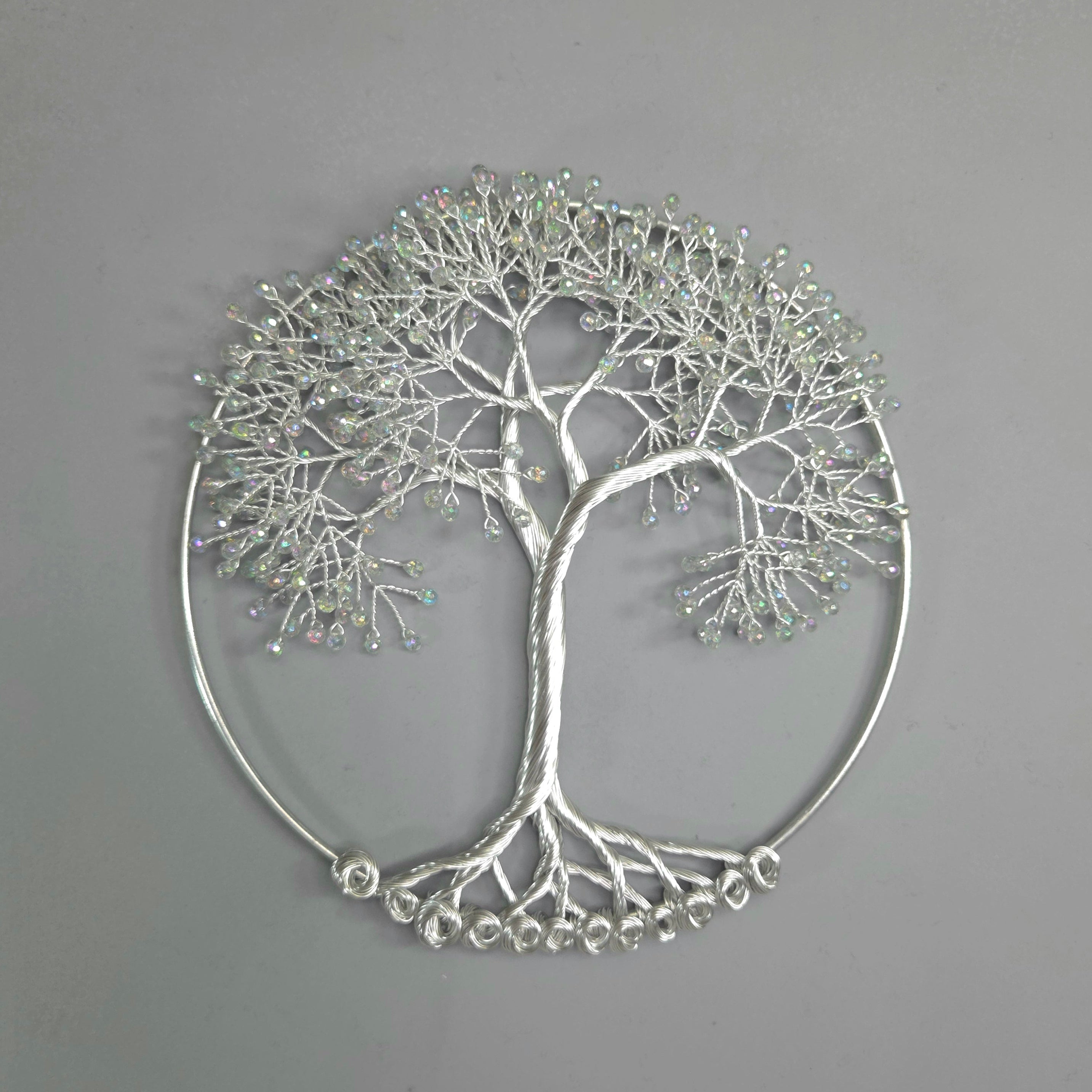 Silver tree-shaped decorative wall art on a gray background