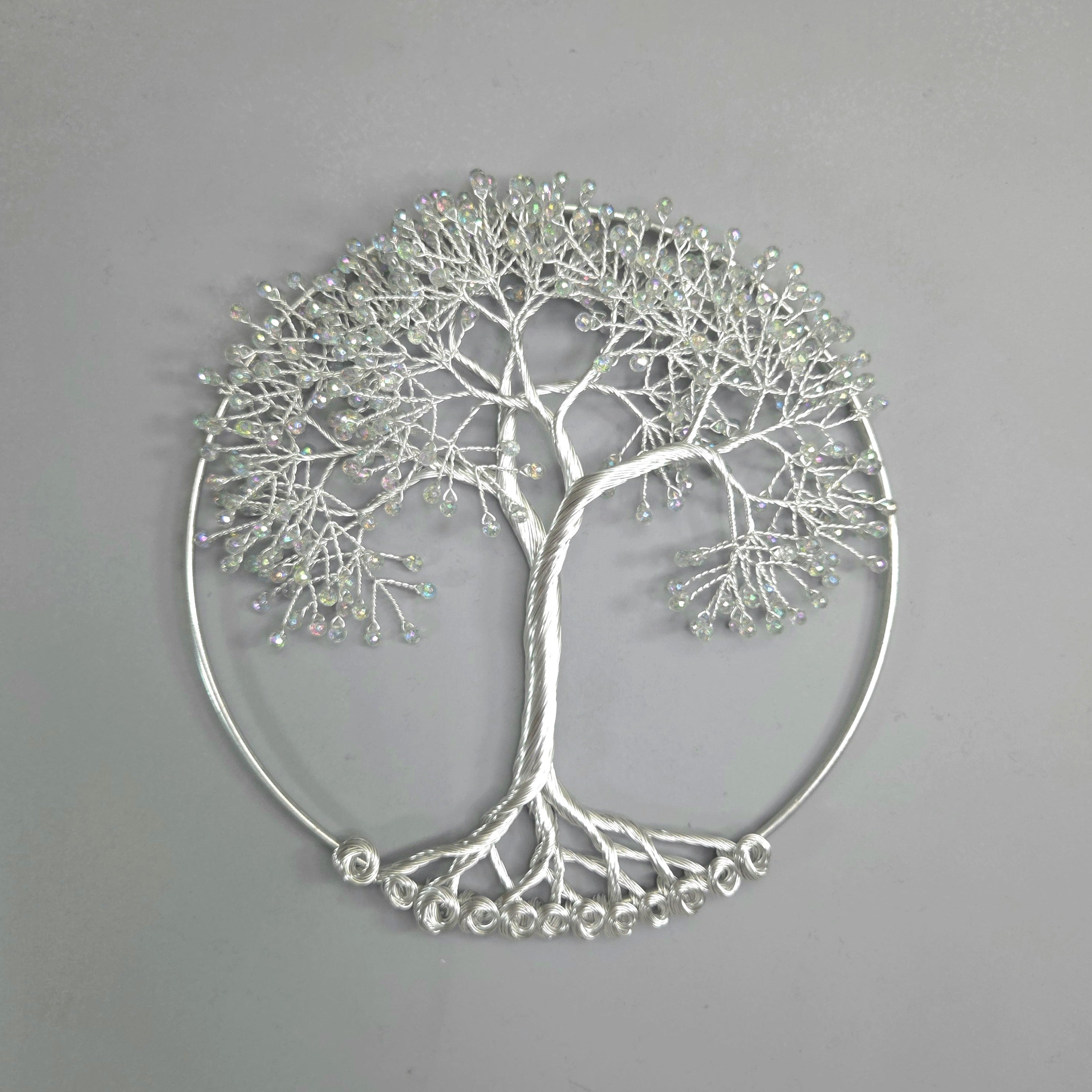 Silver tree-shaped decorative wall art on a gray background