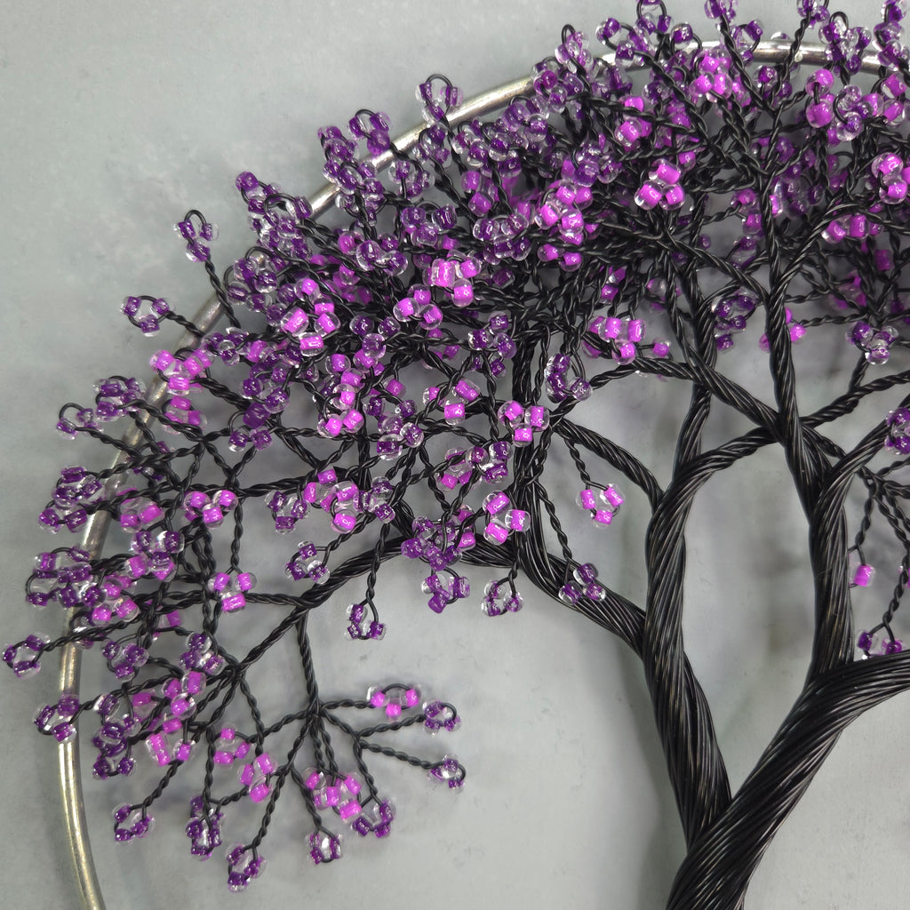 Decorative branch with purple beads on a white background