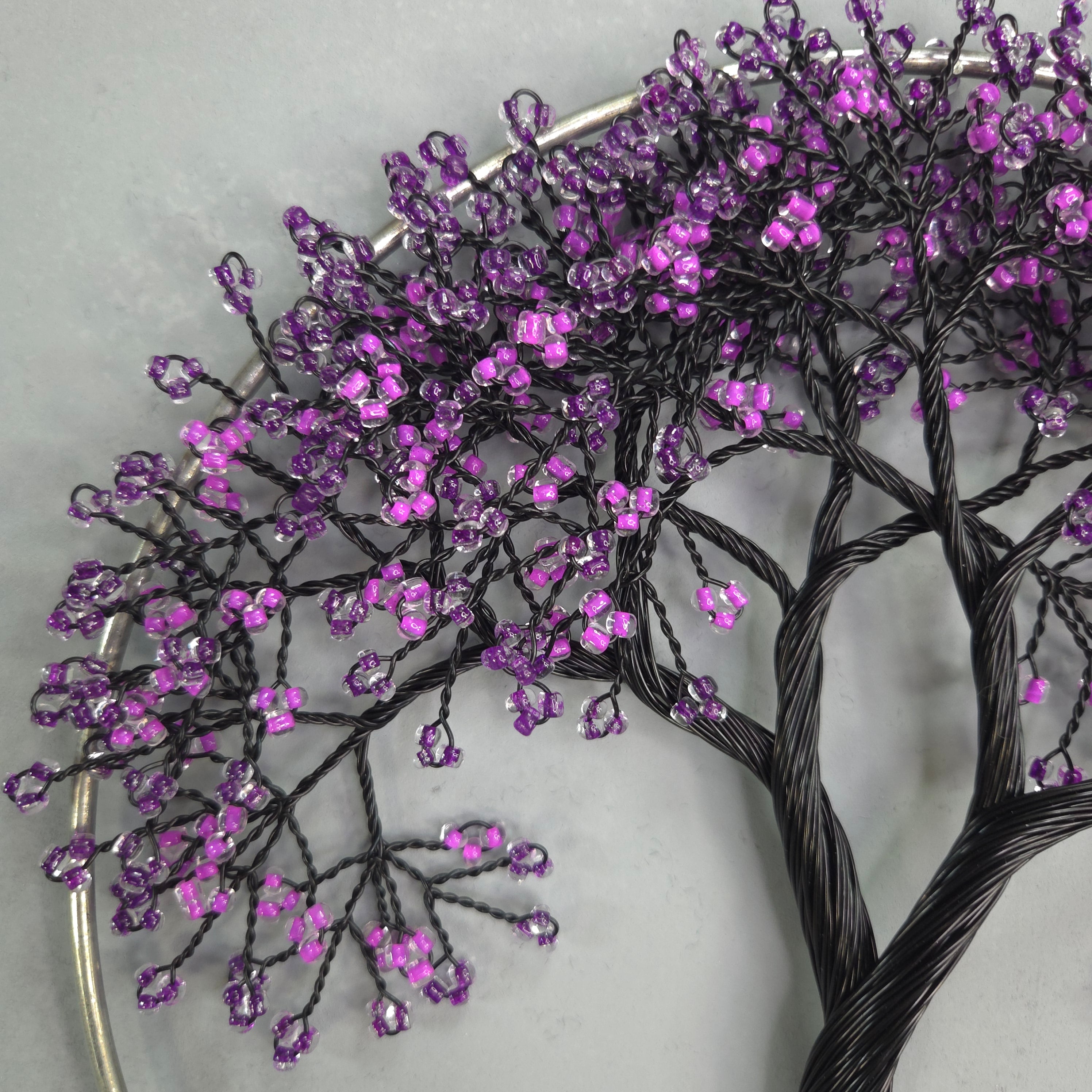 Decorative branch with purple beads on a white background