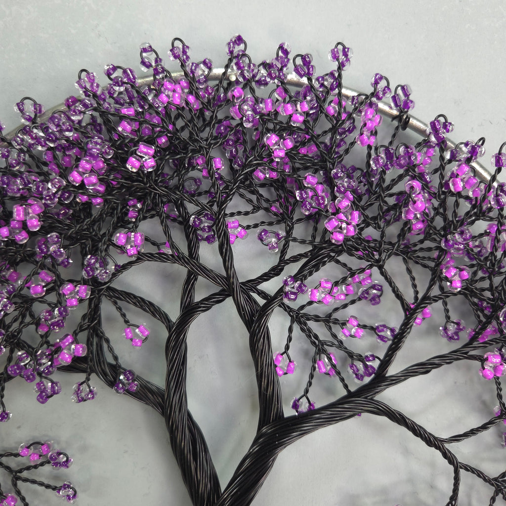 Decorative branch with purple beads on a light gray background