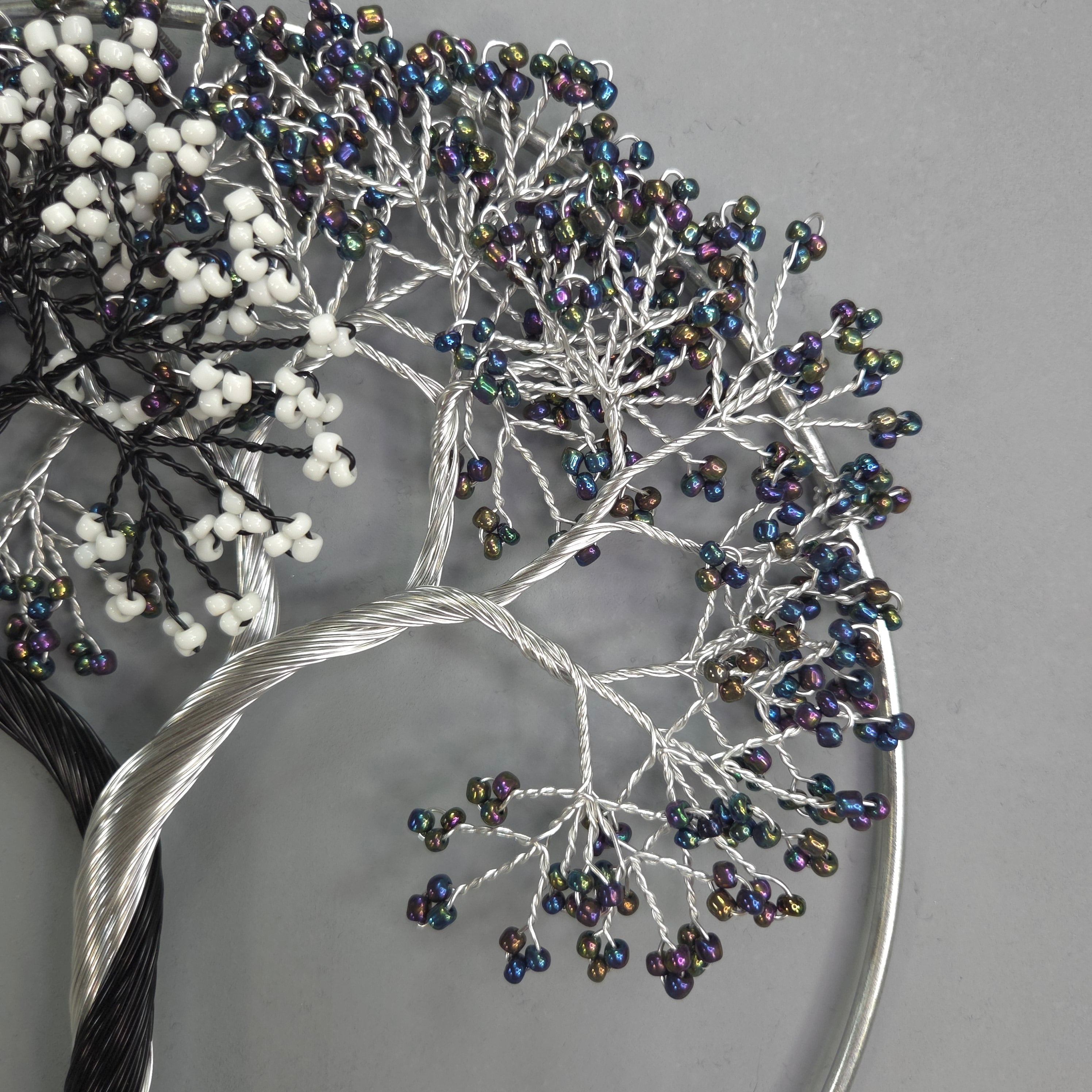 Decorative hair accessory with beaded branches on a gray background