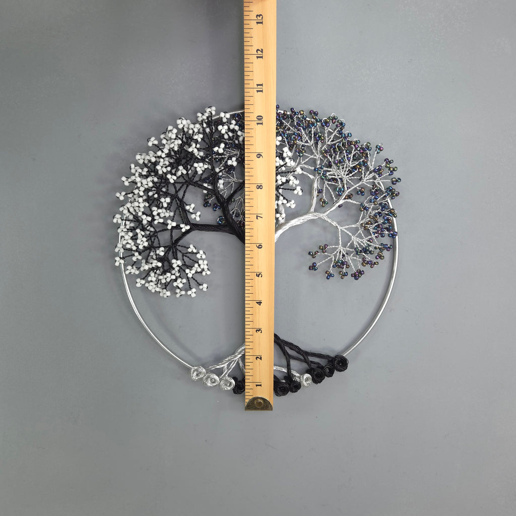 Decorative metal wall art with branches and leaves, measured against a ruler on a gray background