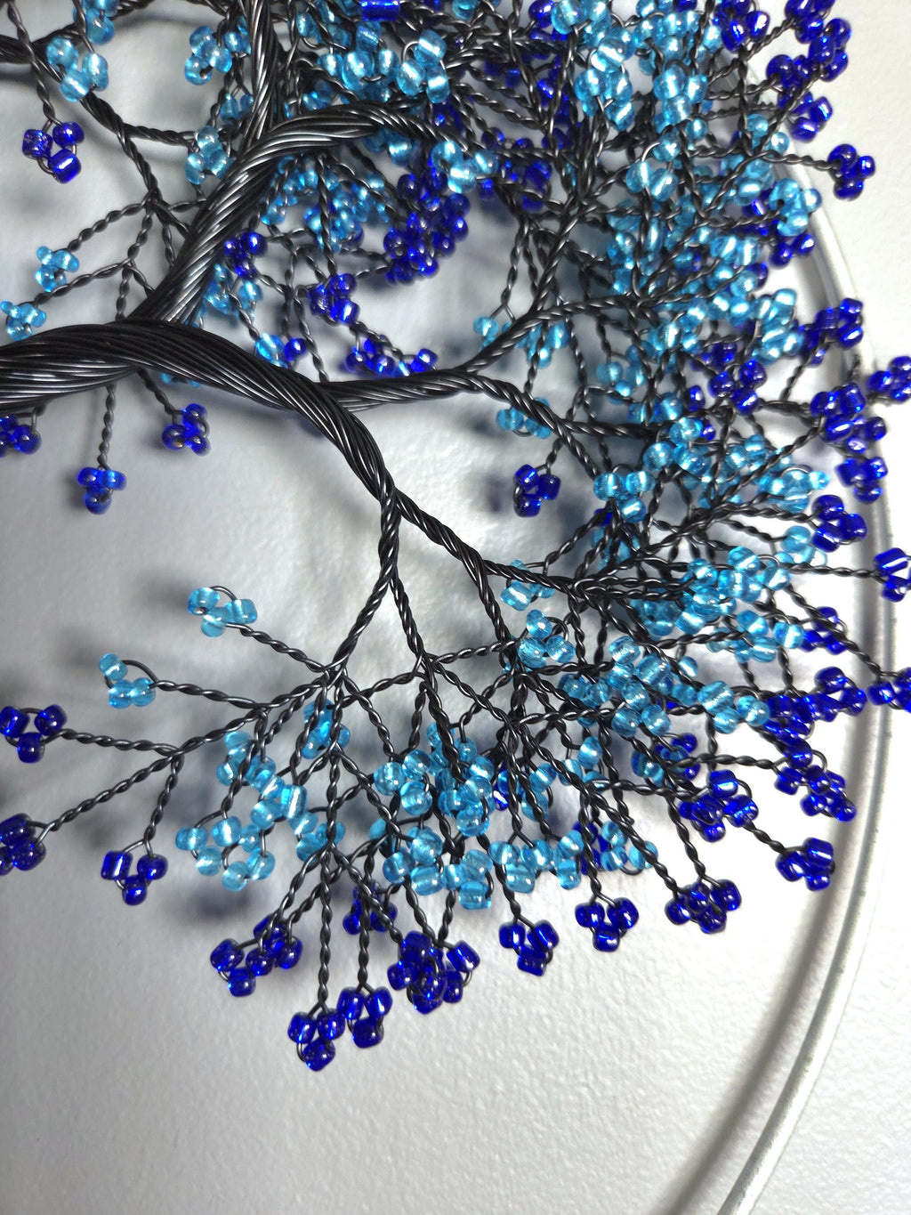 Decorative branch with blue and black beads on a white background