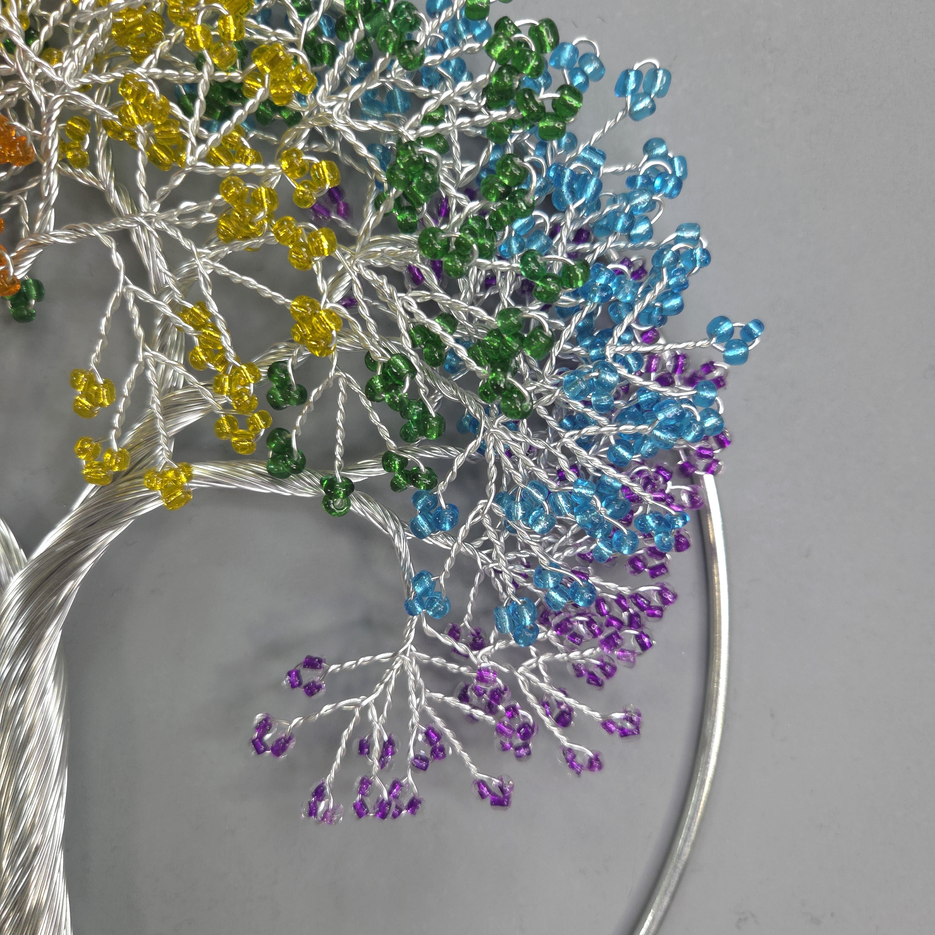 Decorative tree made of beaded branches on a gray background