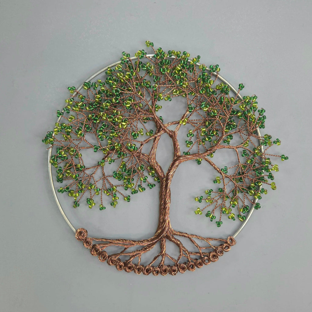 Decorative wall art of a tree with green beads on a gray background