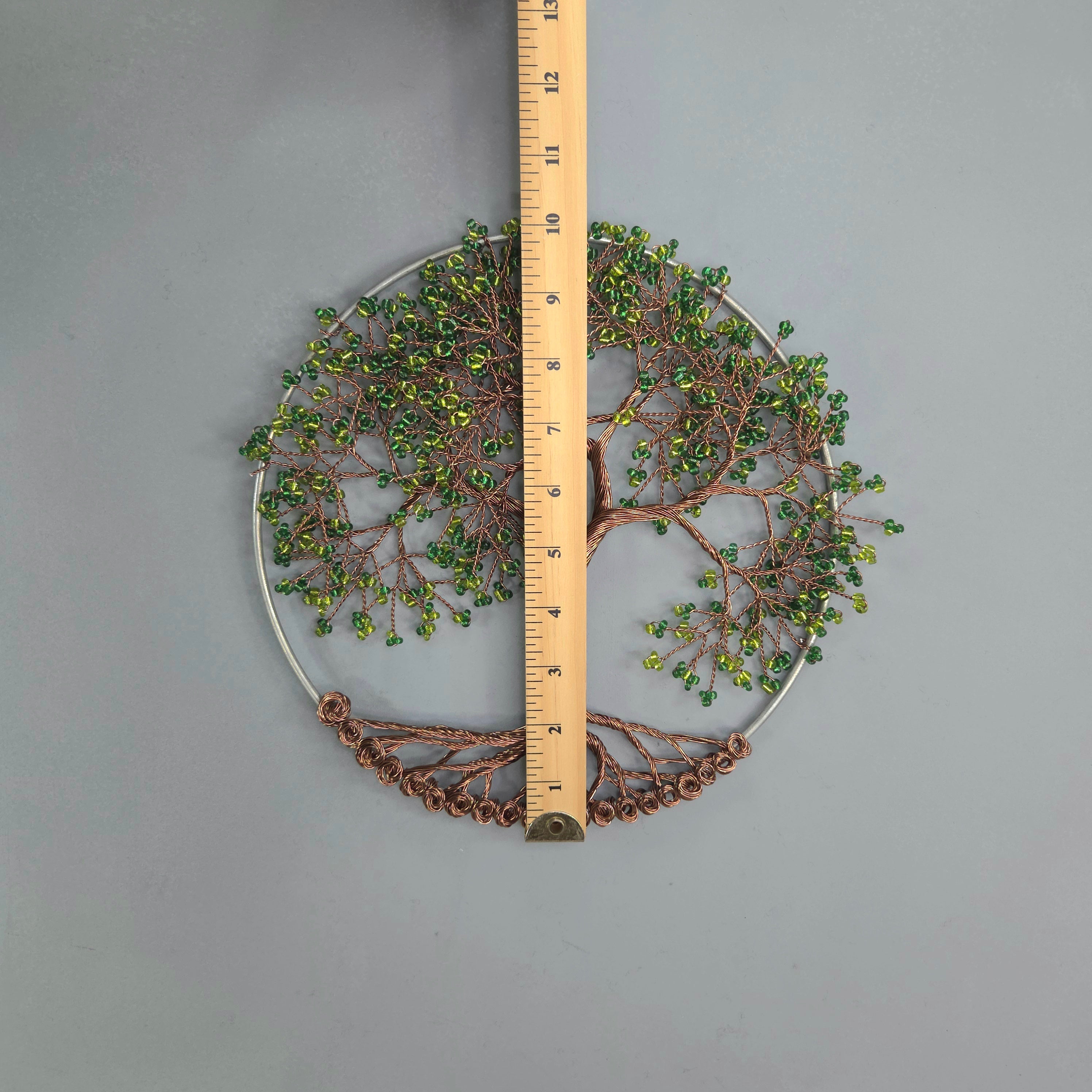 Decorative circular wall art with a ruler for scale on a gray background