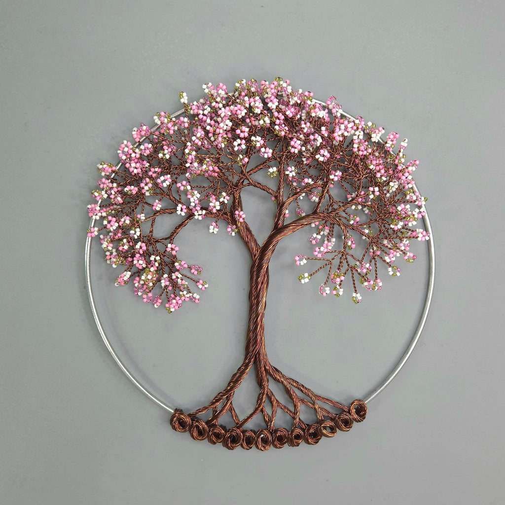 Decorative wall art of a tree with pink blossoms on a gray background