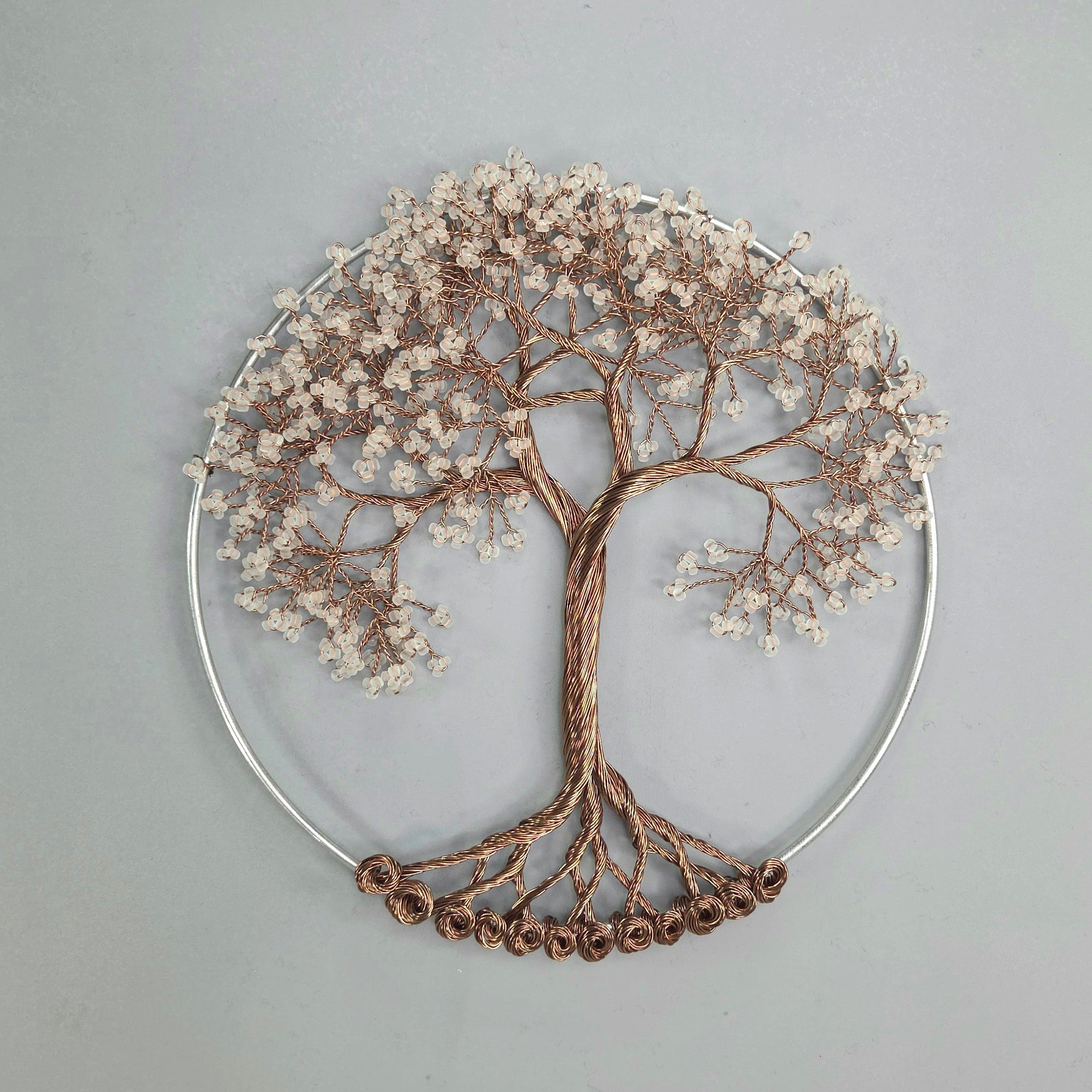 Decorative wall art of a tree with branches and leaves on a gray background