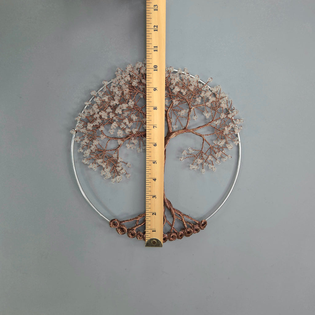 Decorative wreath with branches and flowers, measured against a ruler on a gray background
