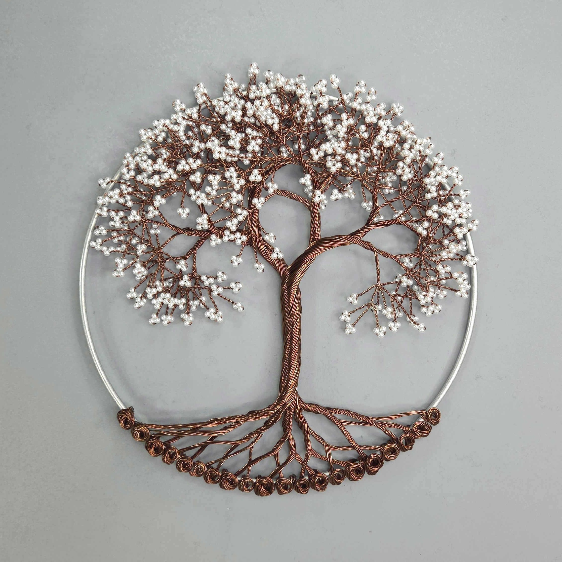Decorative wall art of a tree with branches and leaves on a gray background