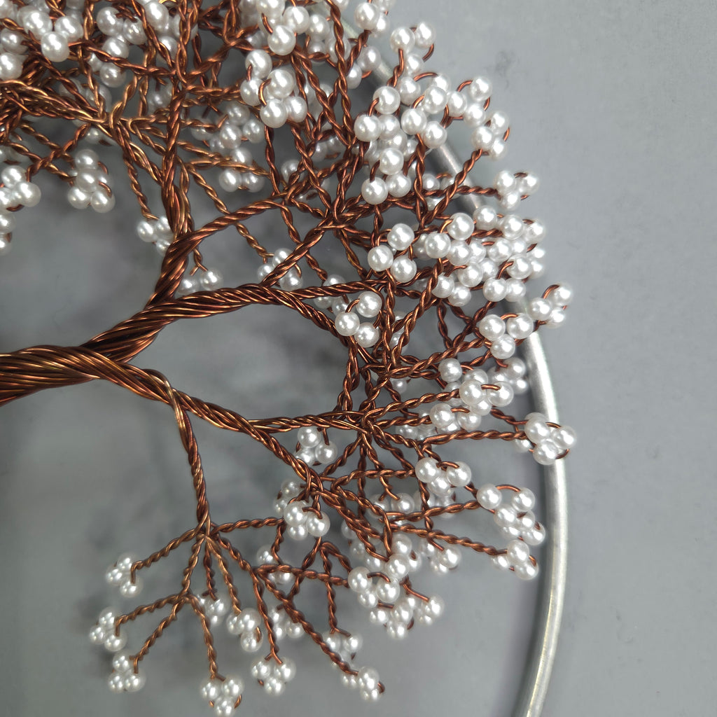 Decorative tree branch with white beads on a gray background