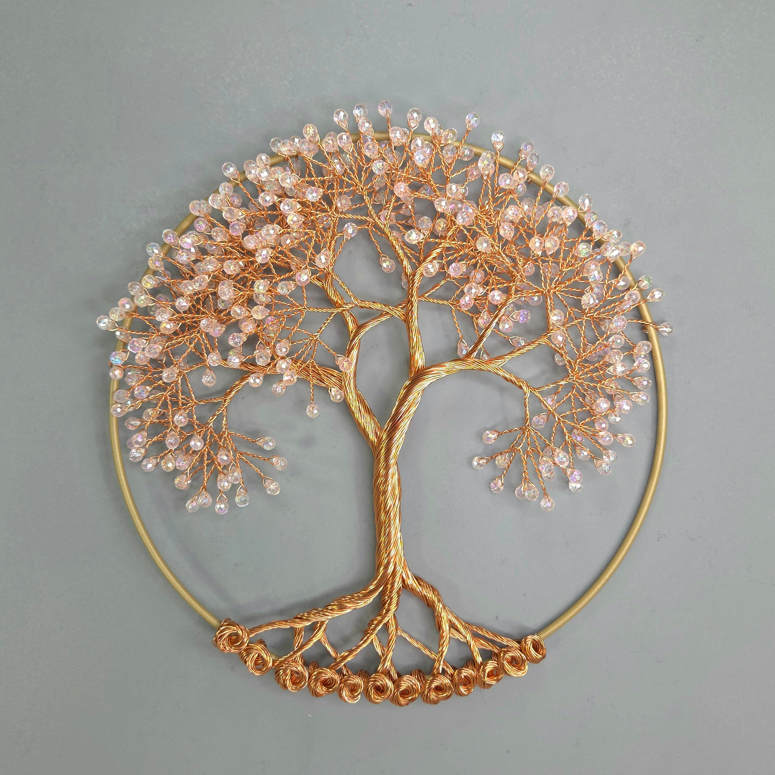 Decorative wall art of a tree with gold branches and beads on a gray background