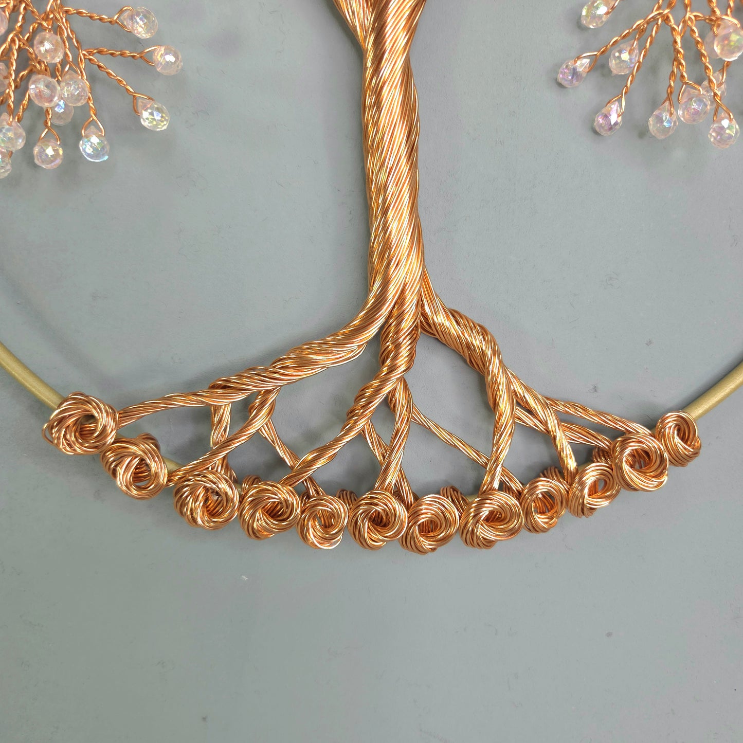 Gold necklace with intricate design on a light gray background