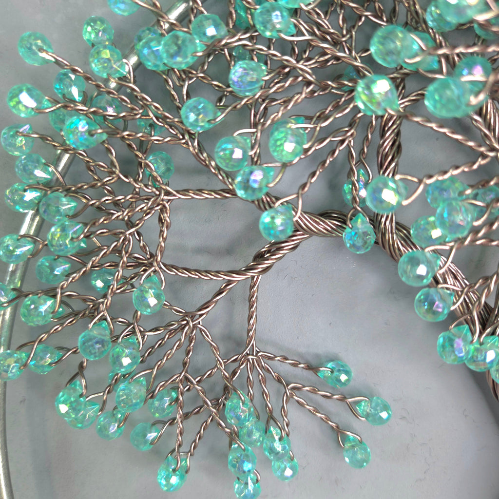Decorative branch with turquoise beads on a light gray background