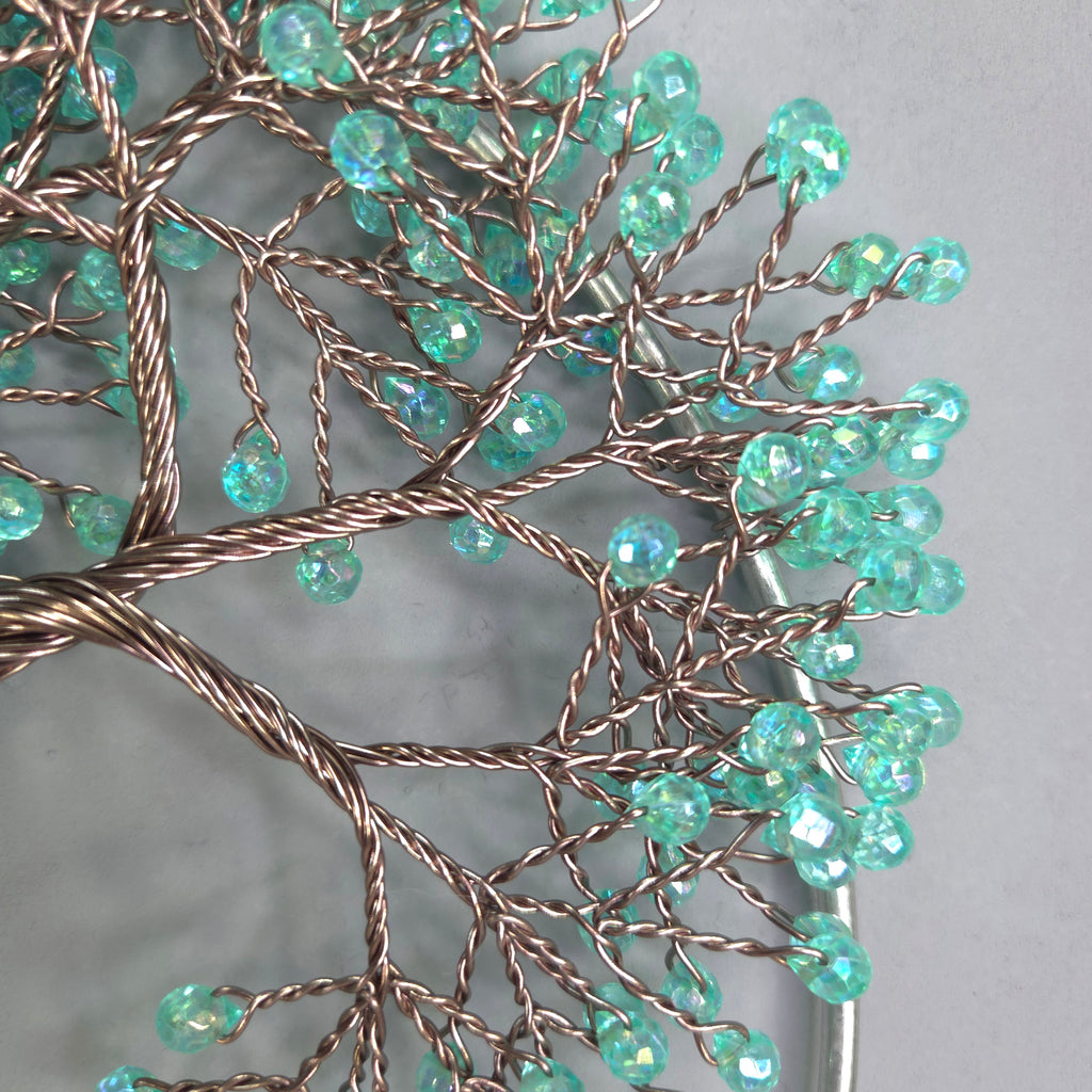 Decorative wall art with turquoise beads on a gray background