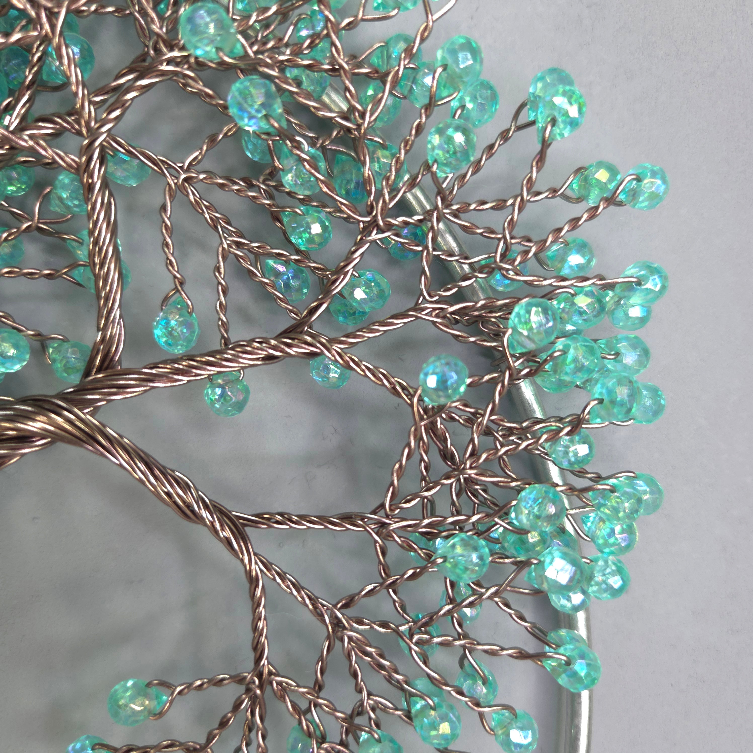 Decorative wall art with turquoise beads on a gray background