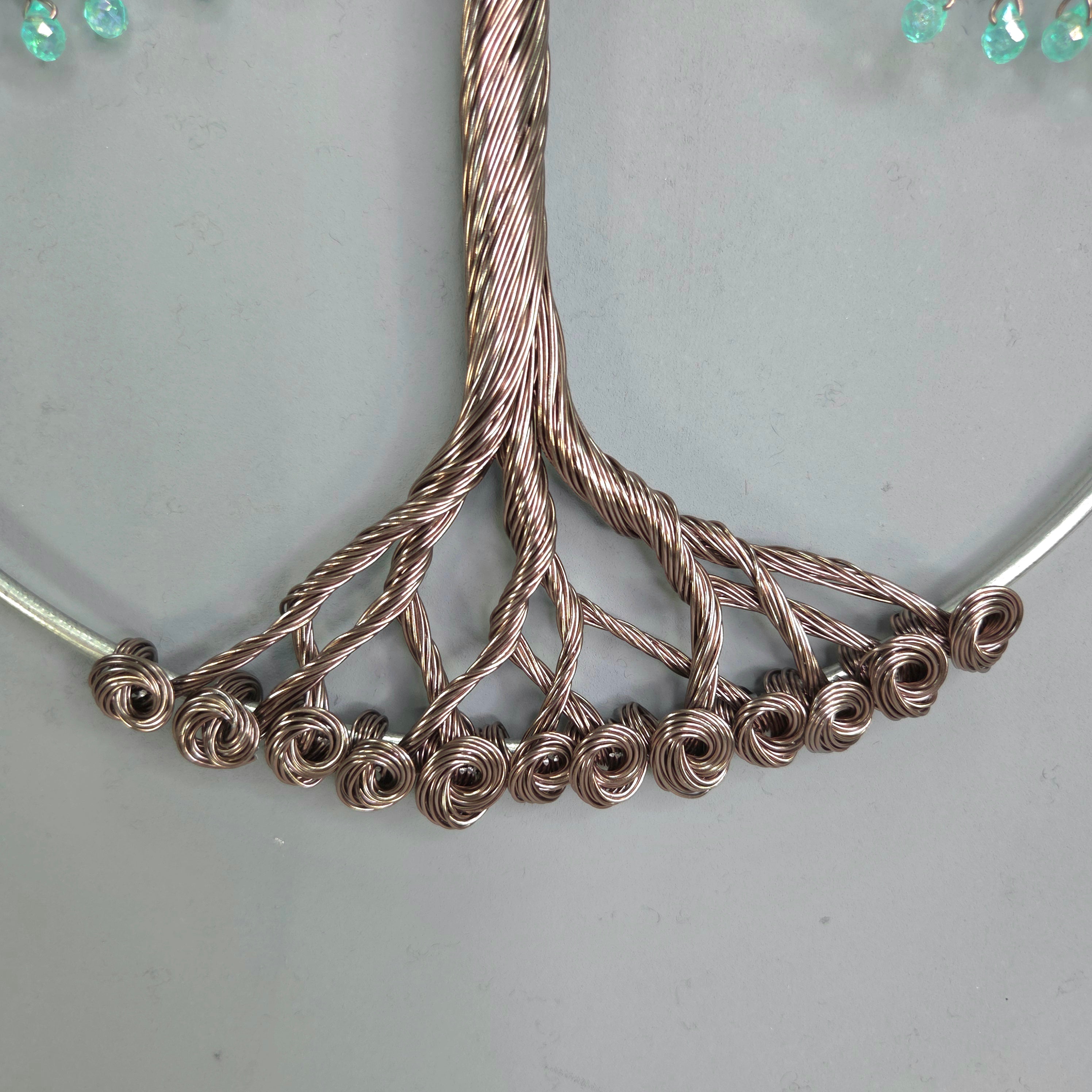 Close-up of a silver necklace with intricate design on a light gray background