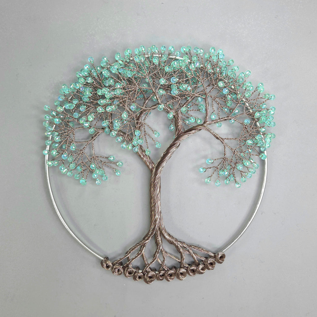 Decorative wall art of a tree with turquoise beads on a gray background