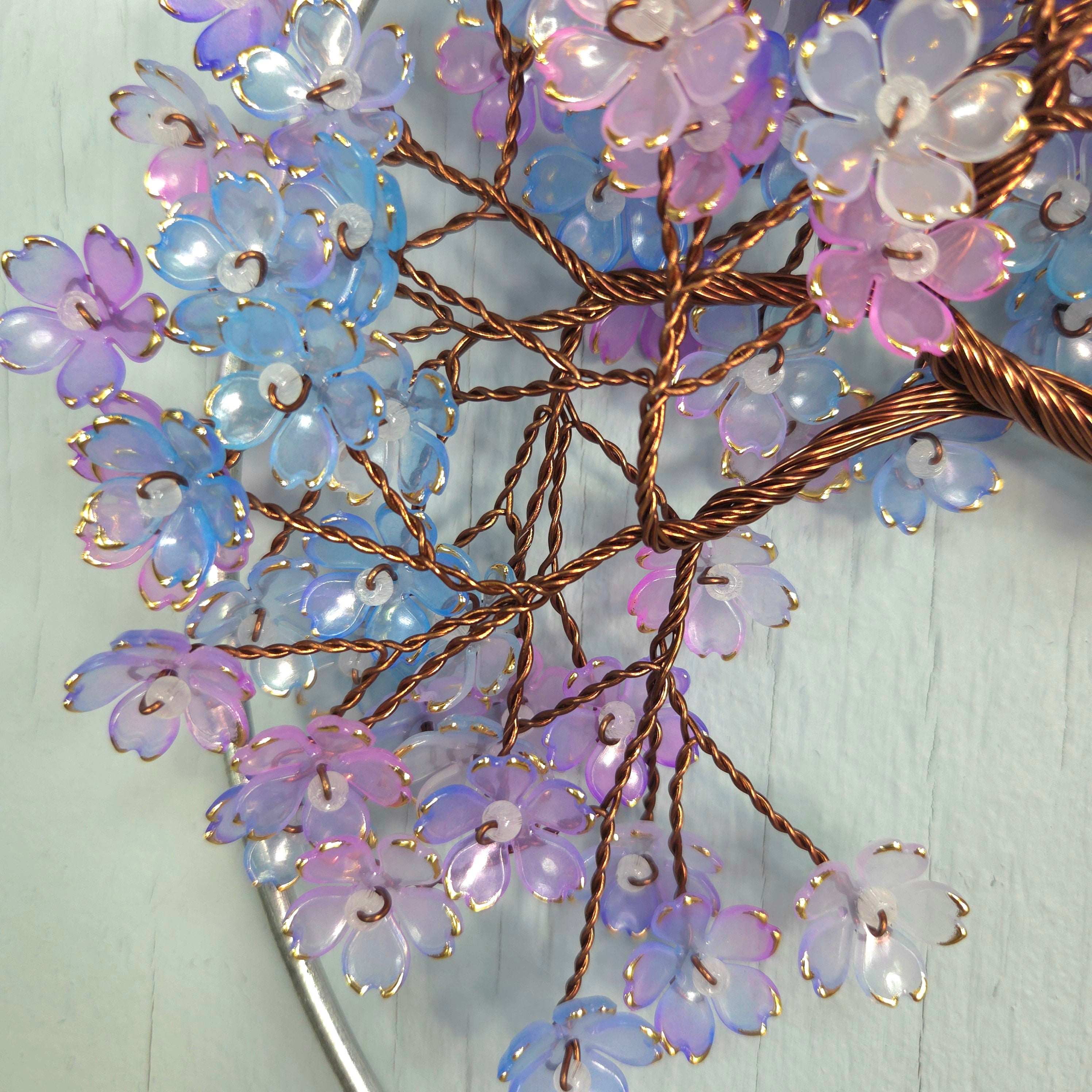 Decorative wall art with floral branches and lights on a light blue background