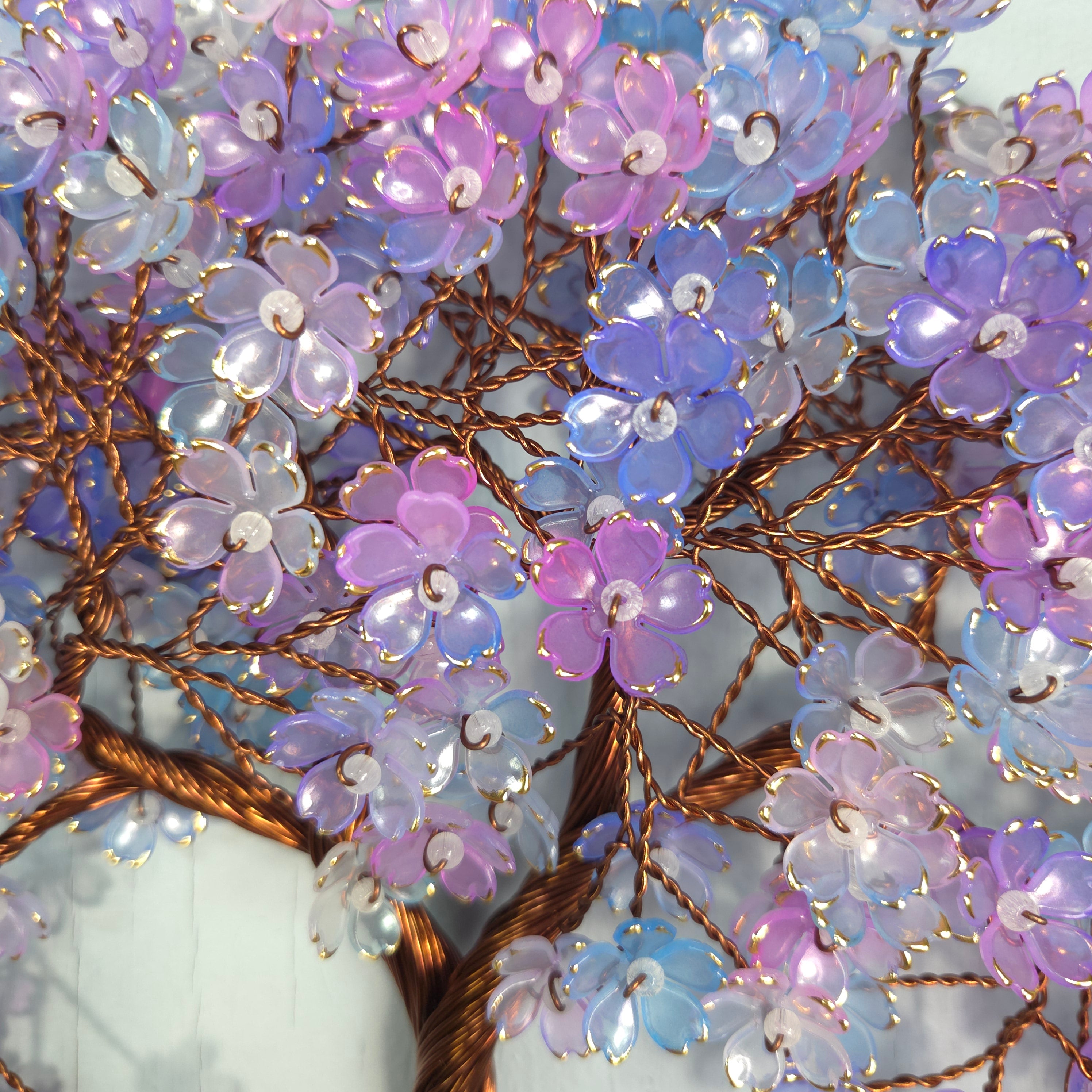 Close-up of a decorative brooch with purple and blue flowers on a white background