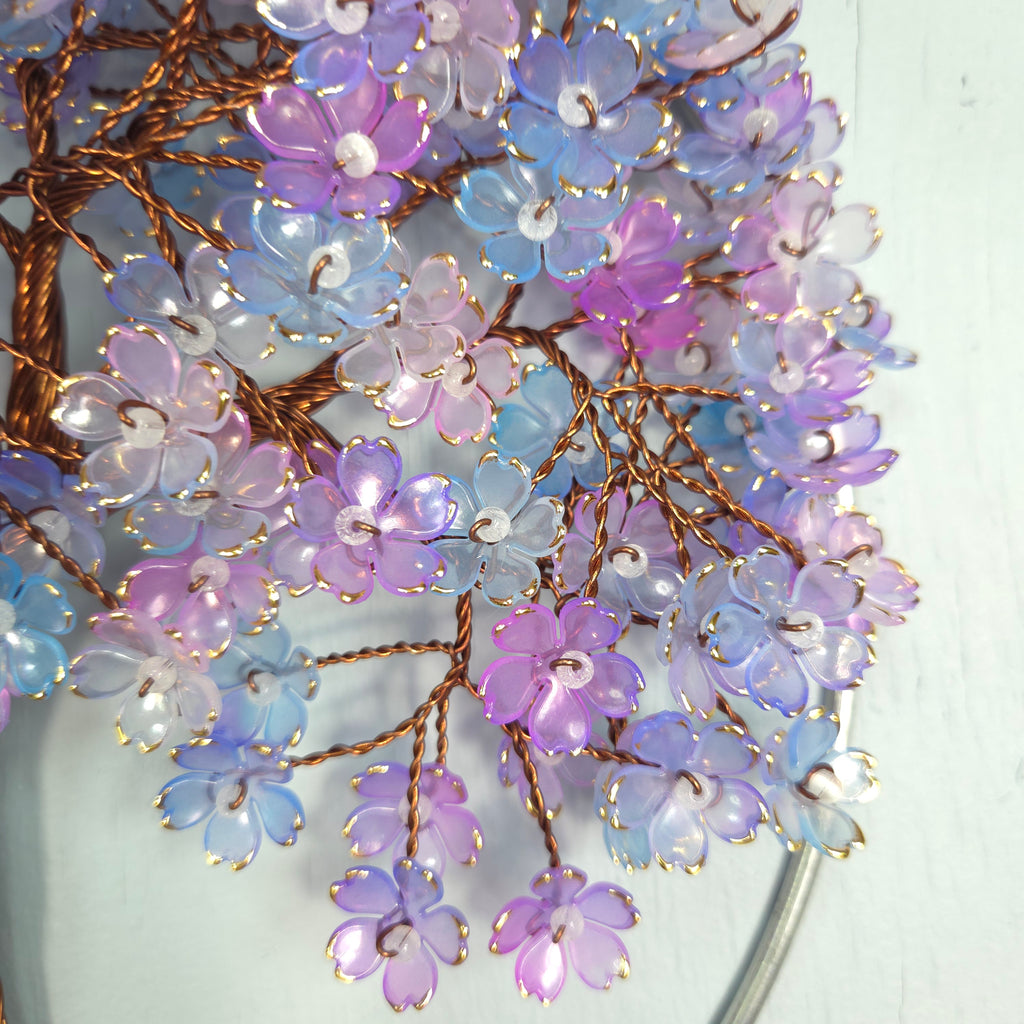 Decorative hair accessory with pastel-colored flowers on a white background