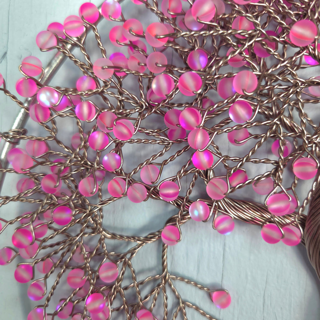 Close-up of pink beads on a string with a white background