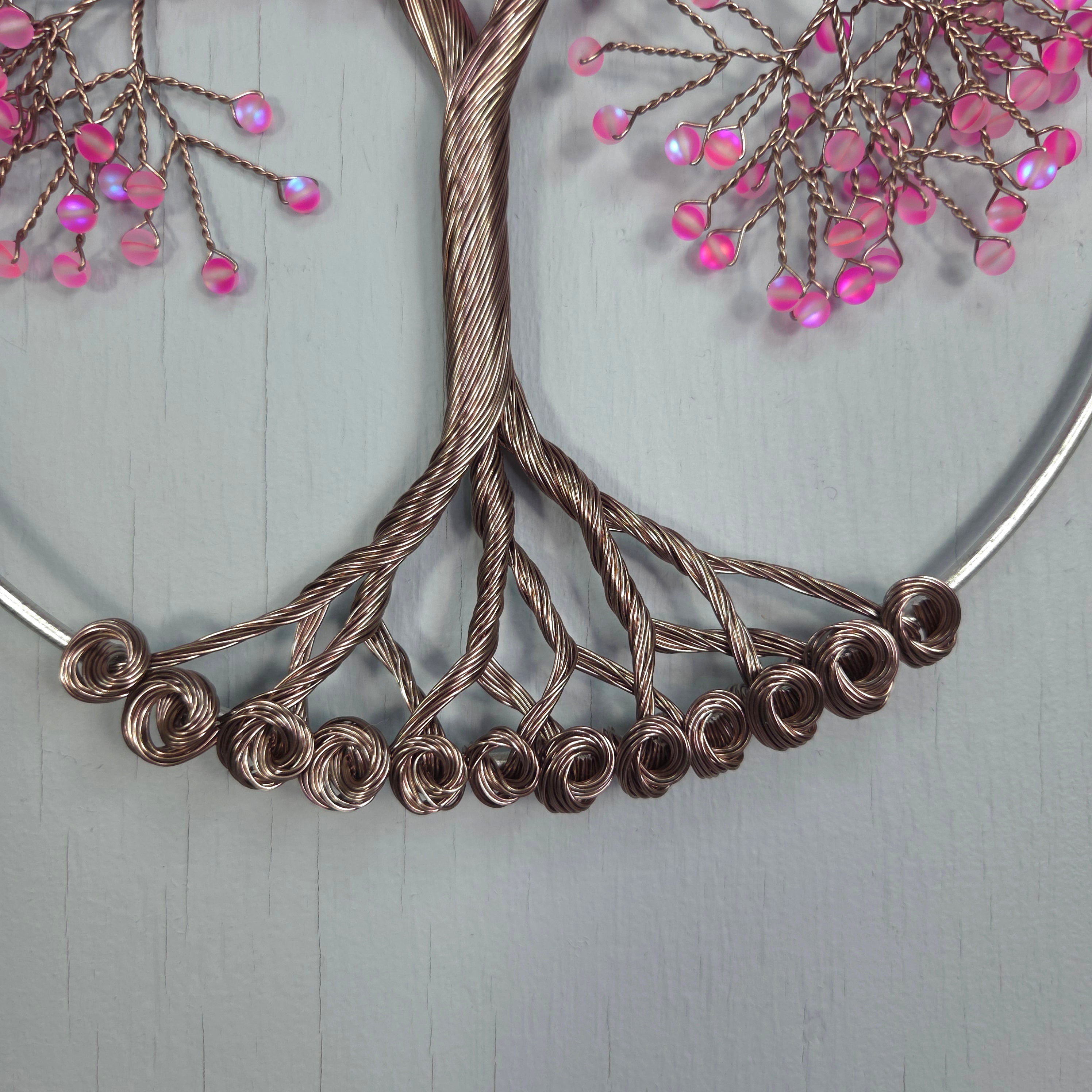 Decorative wreath with wire branches and pink beads on a light gray background