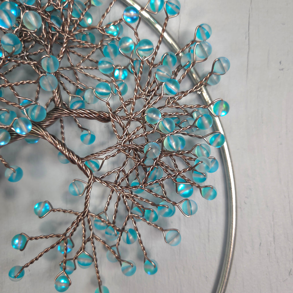 Decorative branch with blue beads on a white background