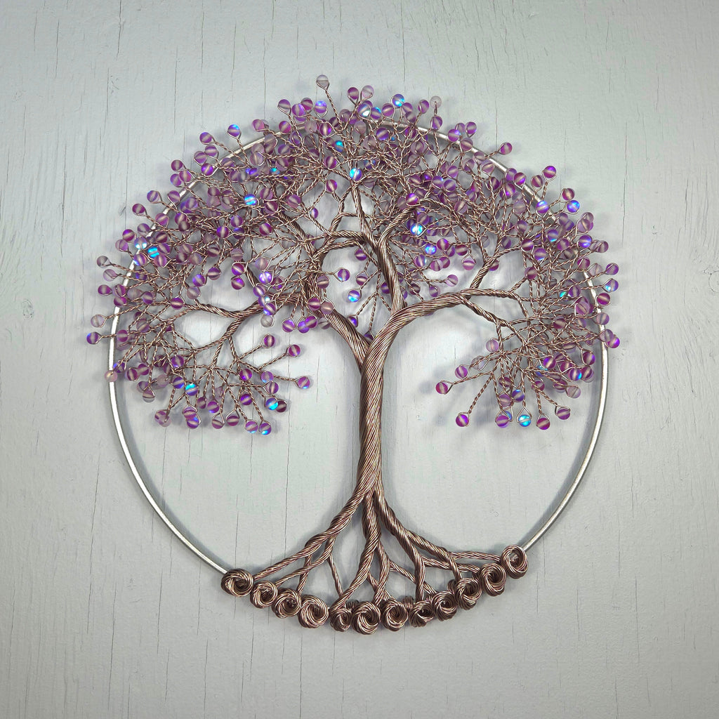Decorative wall art of a tree with purple beads on a light gray background
