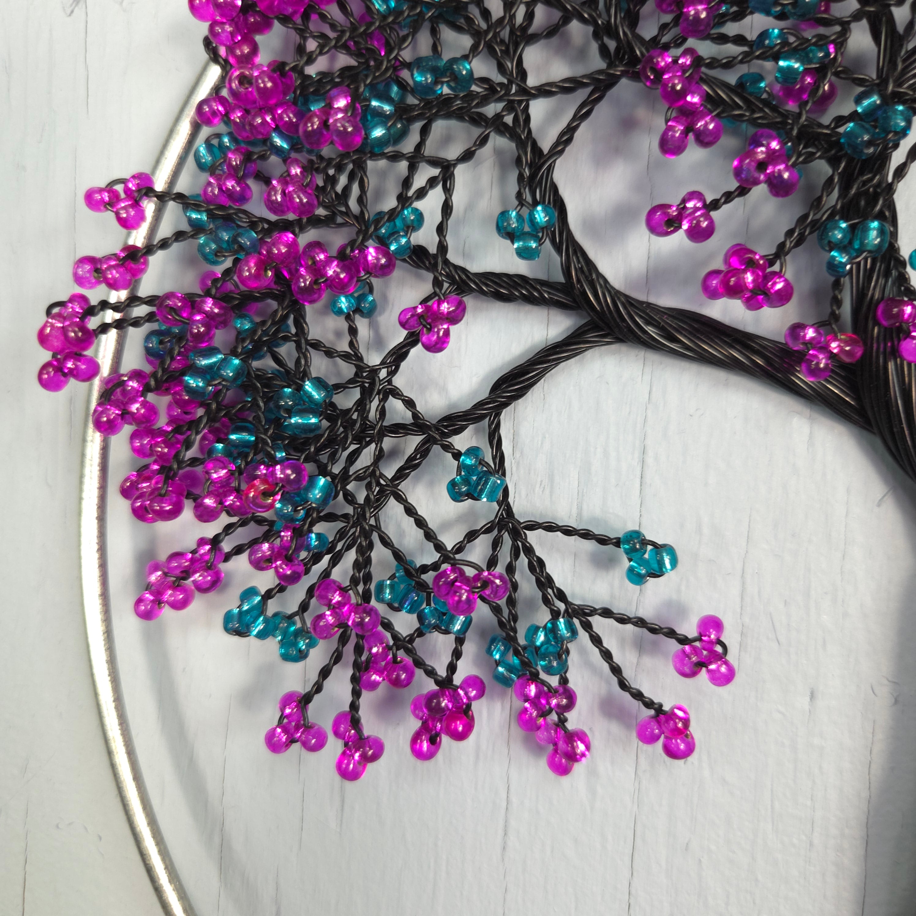 Decorative branch with purple and blue beads on a white surface